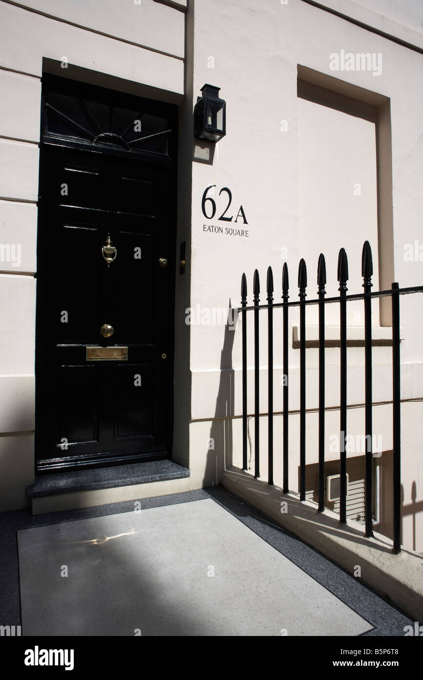 Immacolata di ringhiere e pesanti in vernice lucida porta di numero di piana 62a in esclusiva Eaton Square, a Belgravia Foto Stock