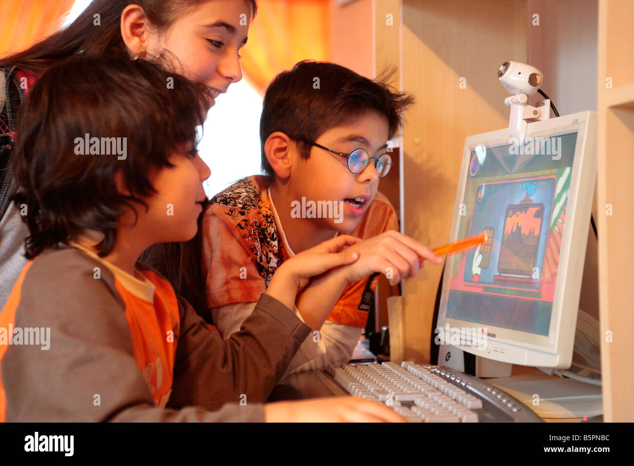 Tre giovani bambini che giocano nonviolenta giochi per computer Foto Stock