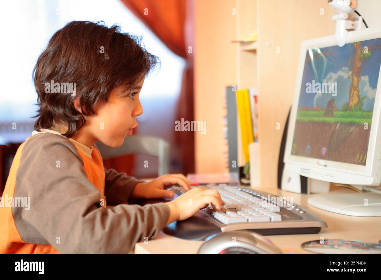 Ritratto di un giovane ragazzo giocando nonviolenta giochi per computer Foto Stock