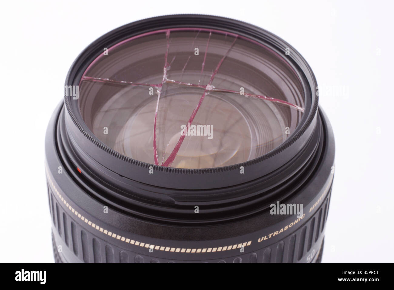 In frantumi filtro UV montato sulla lente della fotocamera su sfondo bianco Foto Stock