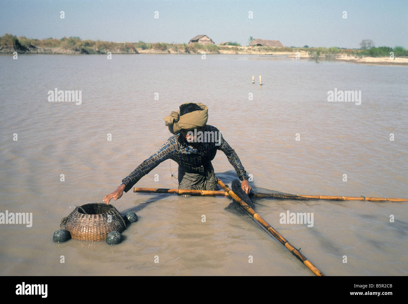 Un pescatore birmano le opere sue reti lungo il fiume Irrawaddy al di fuori di pagane, Birmania o Myanmar. Foto Stock