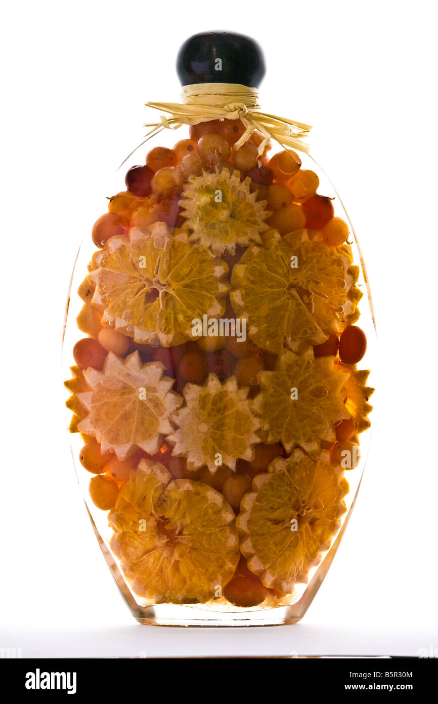Vaso decorativo contengono pezzi di frutta come uva e fettine di arancia in olio di oliva Foto Stock