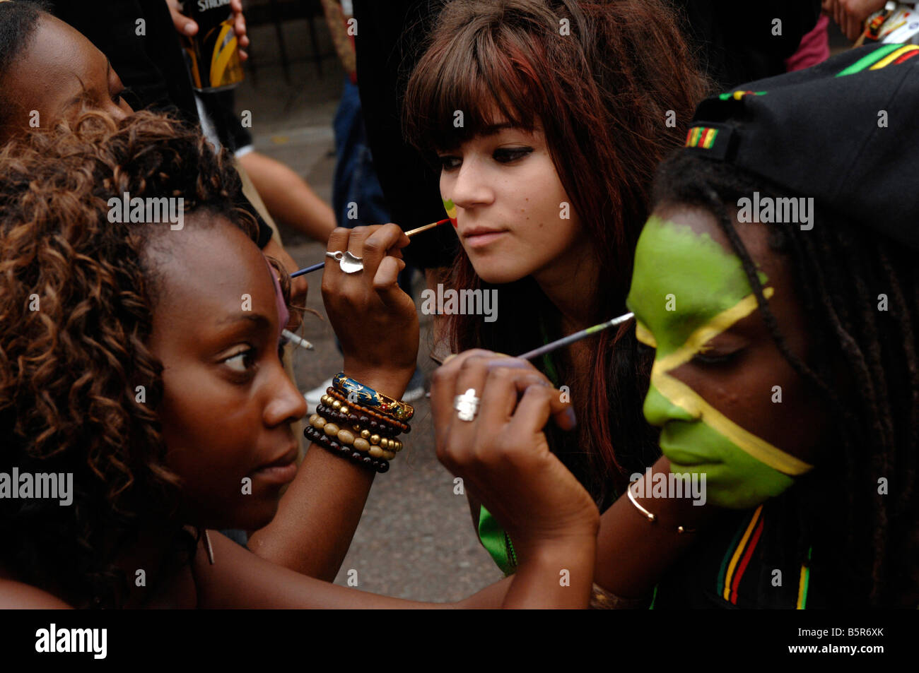 Ragazze faccia dipingere la bandiera giamaicana a 2008's carnevale di Notting Hill Foto Stock