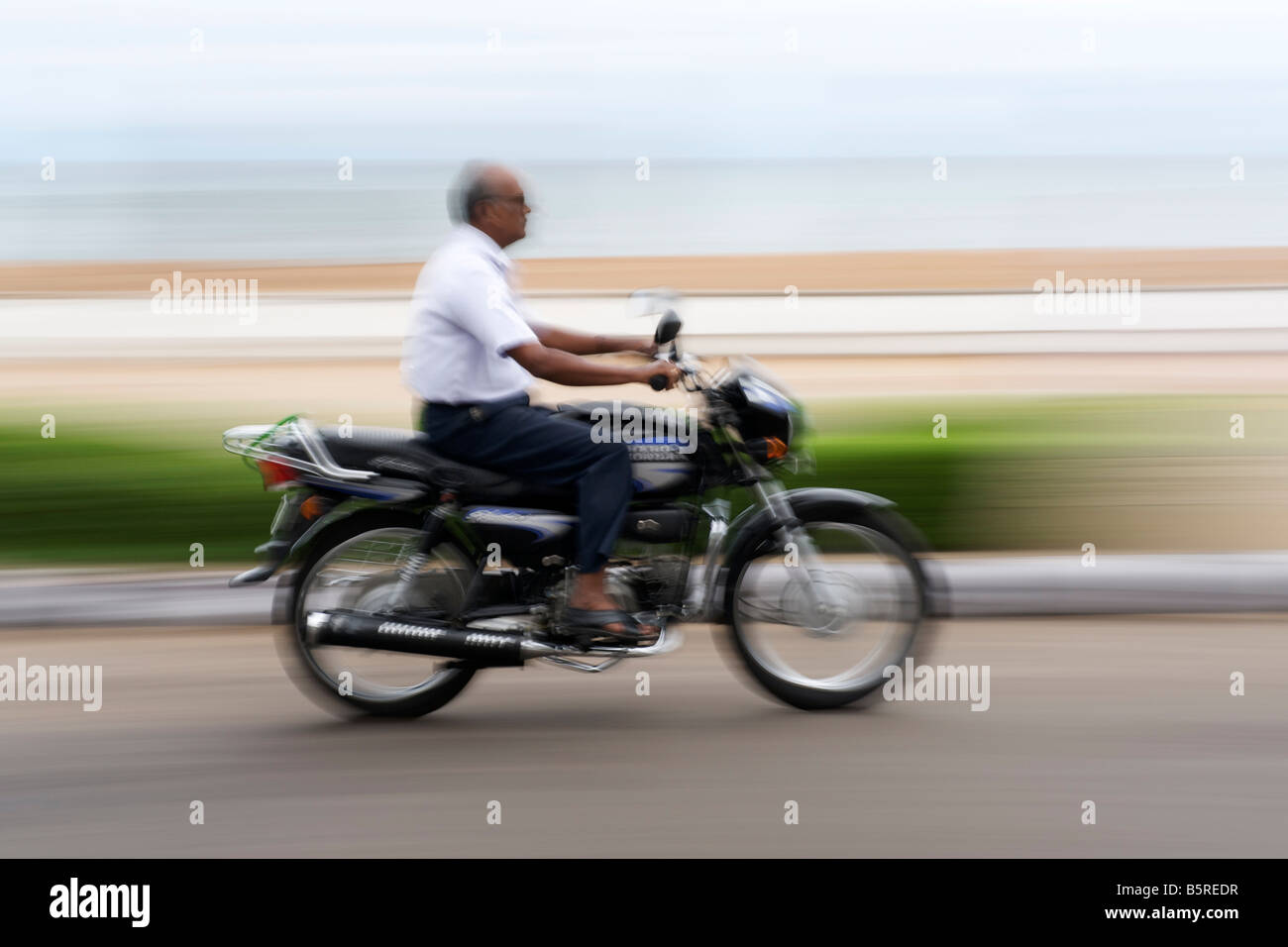 Motociclista sul lungomare di Pondicherry in India. Foto Stock