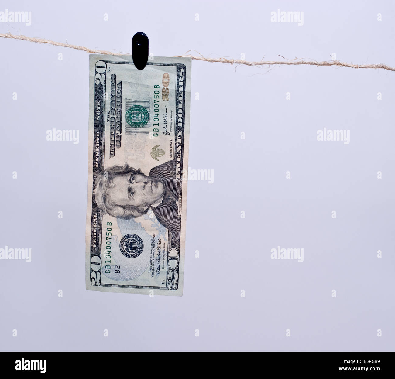 American venti dollari appeso a un clip da un pezzo di spago marrone. Foto Stock