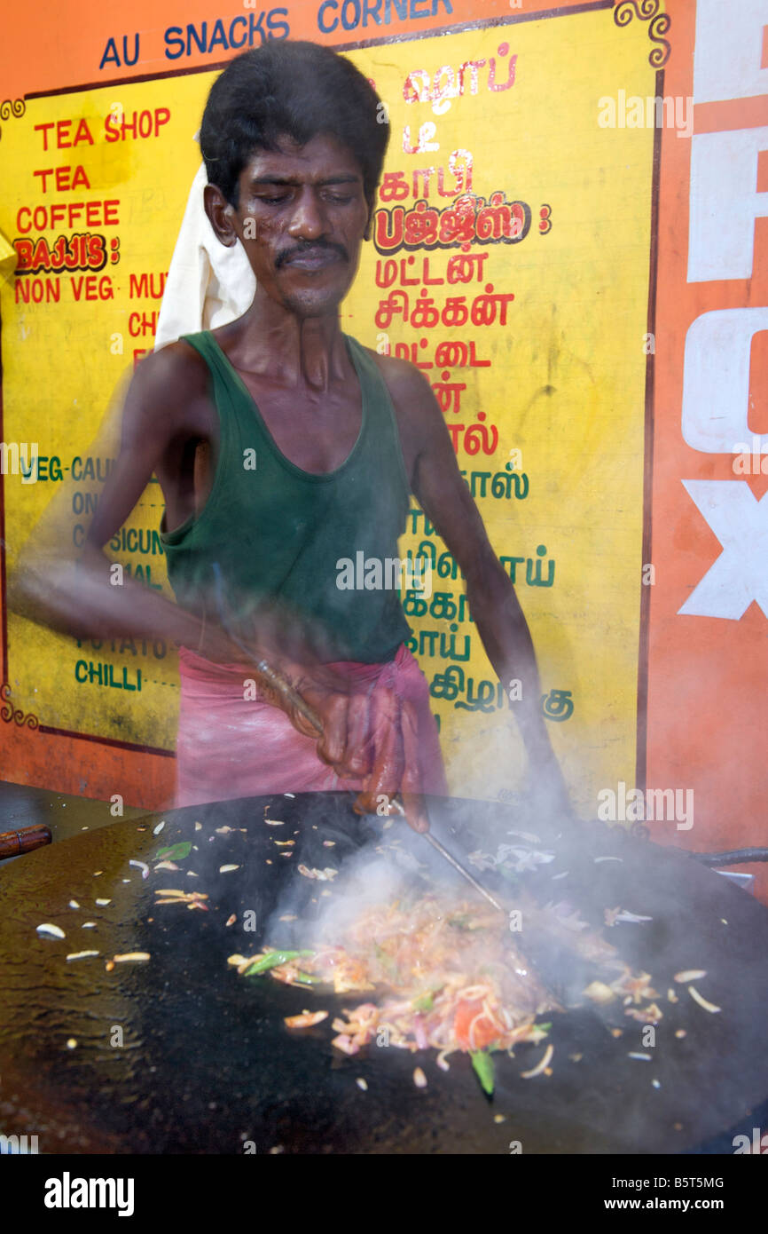 Uomo del sud di cucina in stile indiano uova strapazzate in corrispondenza di un bordo strada dhaba di Pondicherry India. Foto Stock