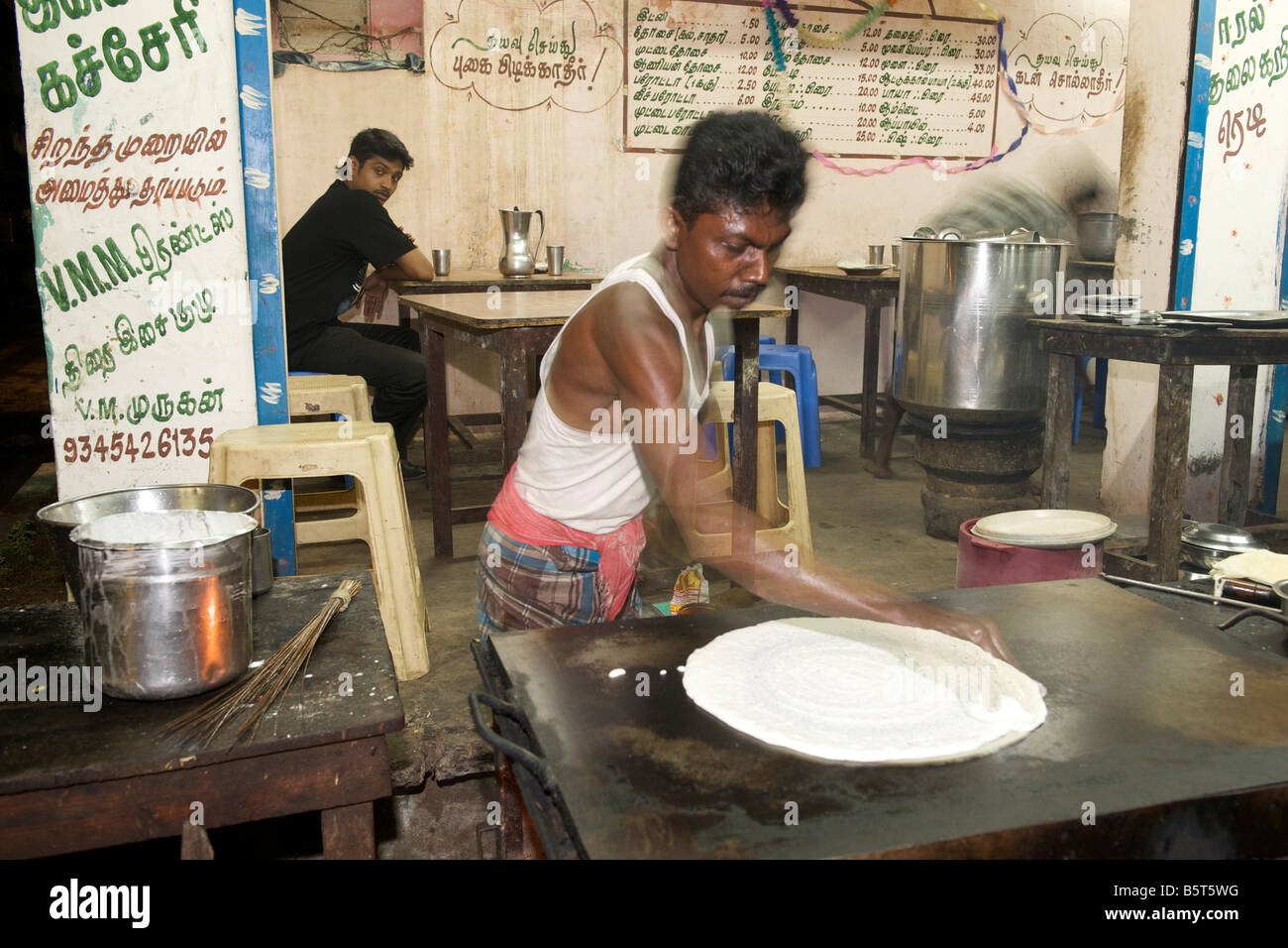 Dosa, a sud di un pancake Indiano essendo disposta in corrispondenza di un bordo strada dhaba di Pondicherry India. Foto Stock