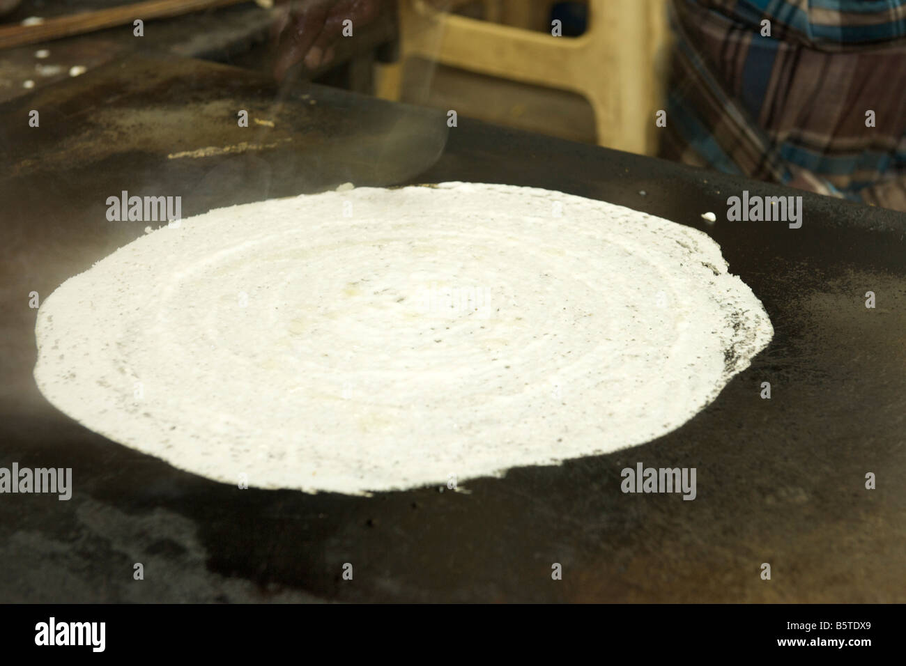 Dosa, a sud di un pancake Indiano essendo disposta in corrispondenza di un bordo strada dhaba di Pondicherry India. Foto Stock