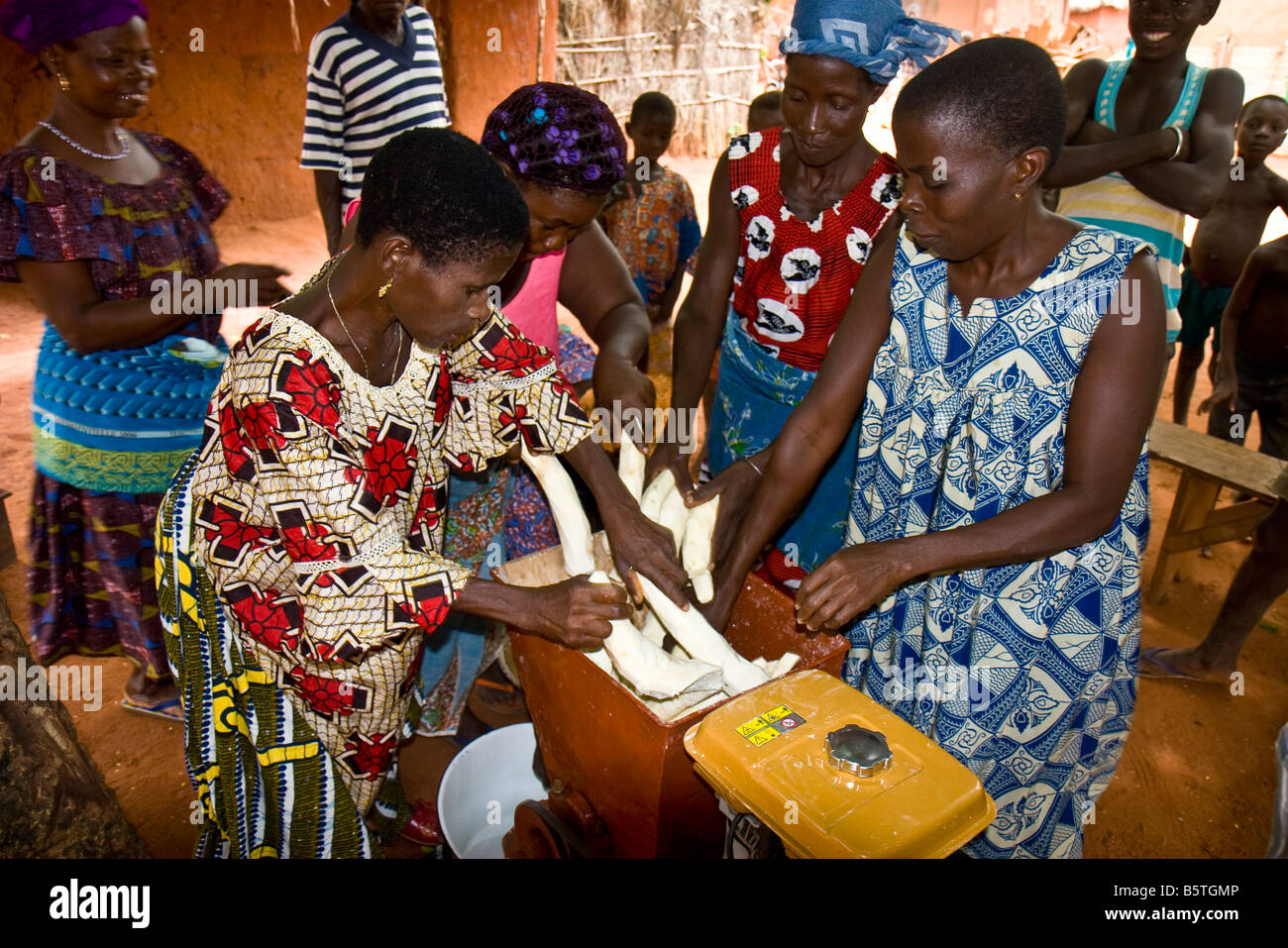 Le donne utilizzano una macchina acquistata tramite un micro-credito prestito per macinare la manioca per la vendita. Foto Stock