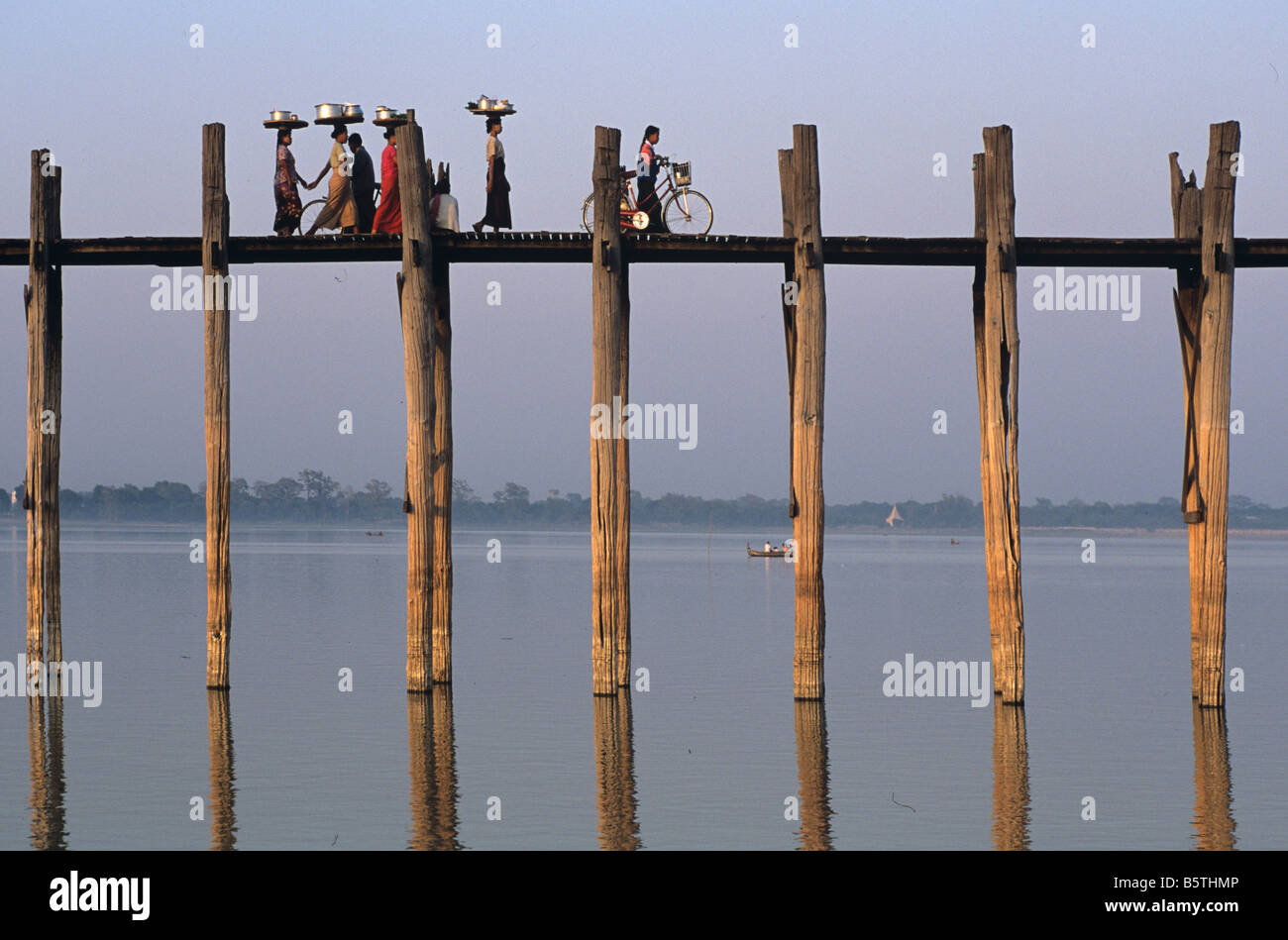 Donne birmane cross U Bein's Bridge, la più lunga del mondo ponte in teak e il Lago Taungthaman ad Amarapura, Mandalay Birmania o Myanmar Foto Stock
