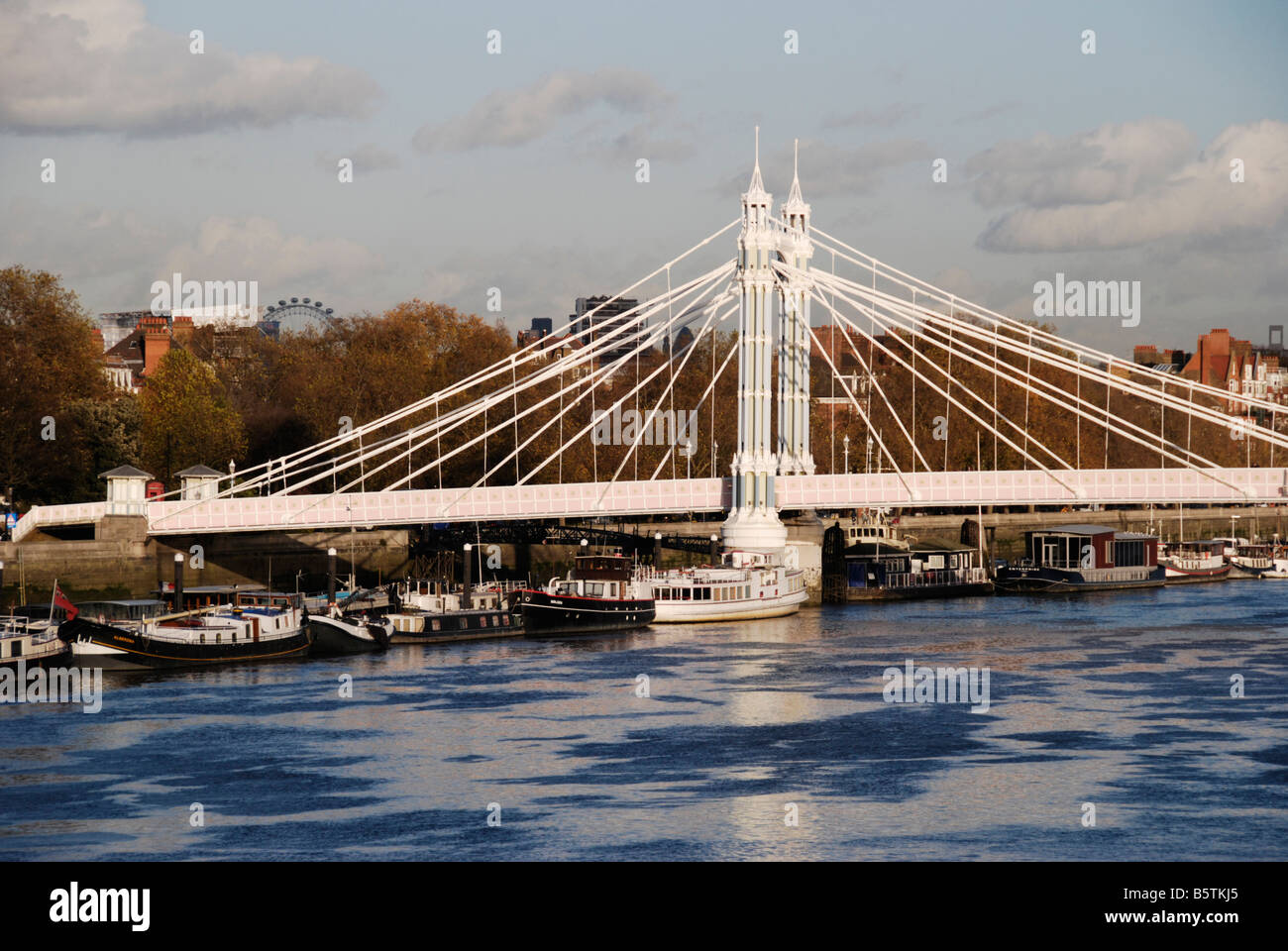 Albert Bridge e ormeggiate barche sul Fiume Tamigi Chelsea London Inghilterra England Foto Stock