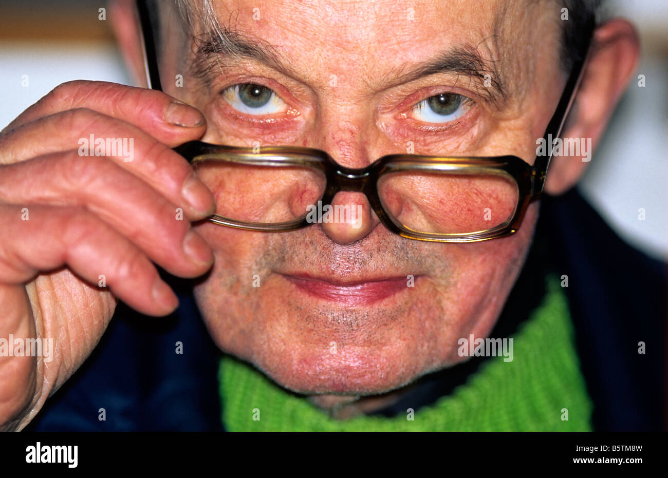 Uomo anziano il sollevamento / abbassamento occhiali, UK. Foto Stock