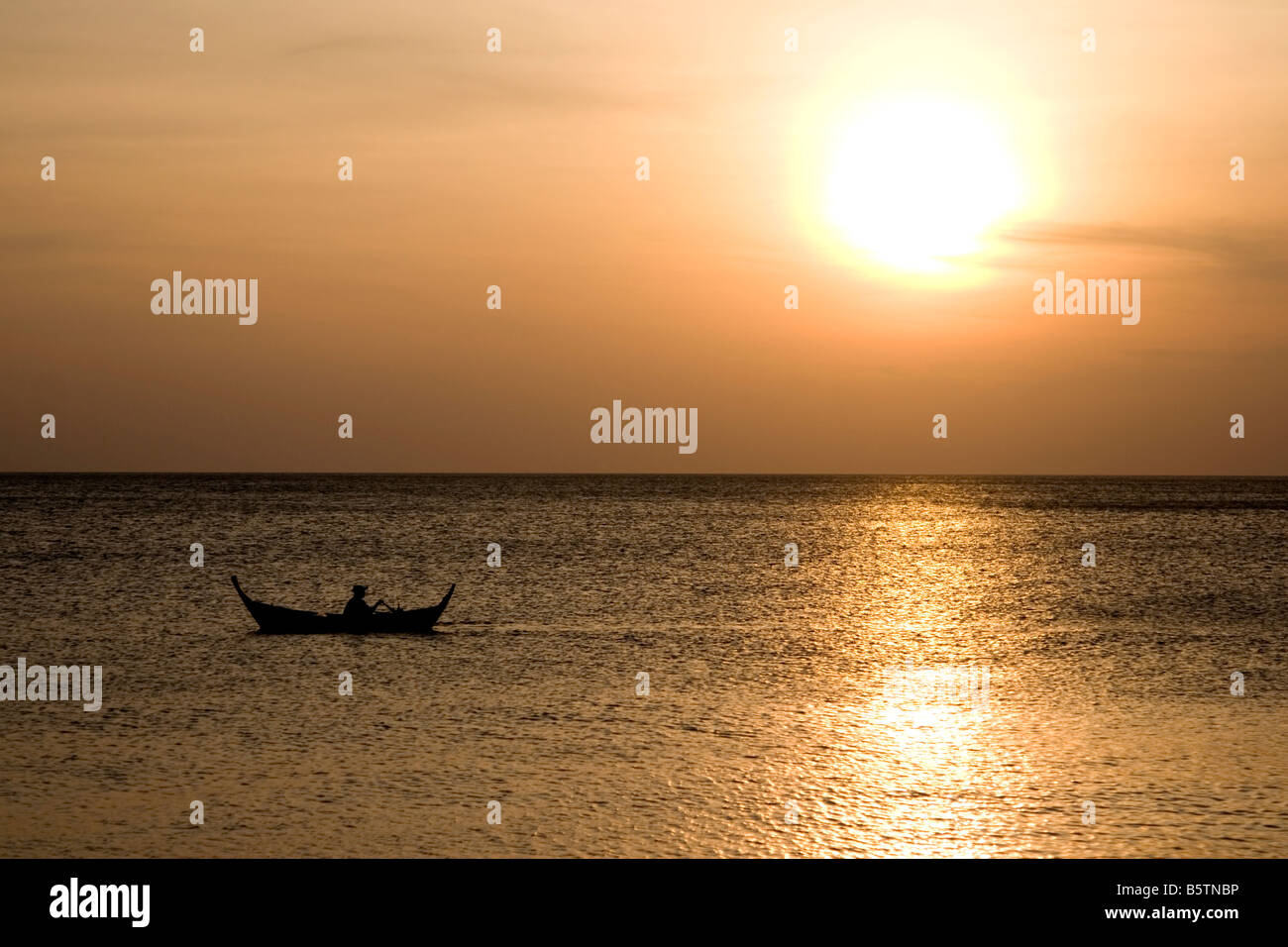 Sguazzare in un rustico canoe di legno nel Mare delle Andamane off della Thailandia. Foto Stock