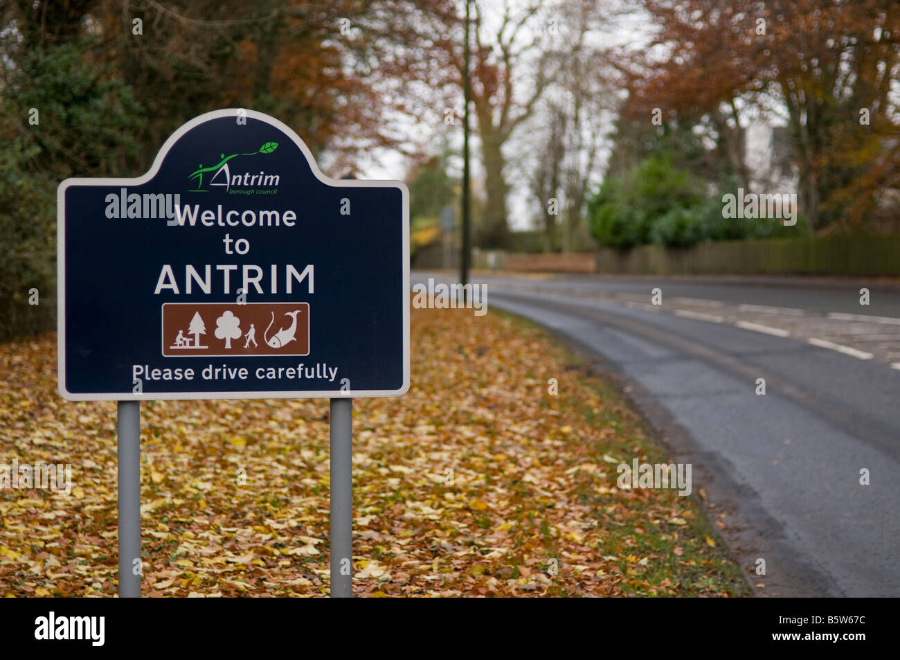 Cartello Benvenuti a Antrim, si prega di guidare con prudenza, con foglie di autunno Foto Stock