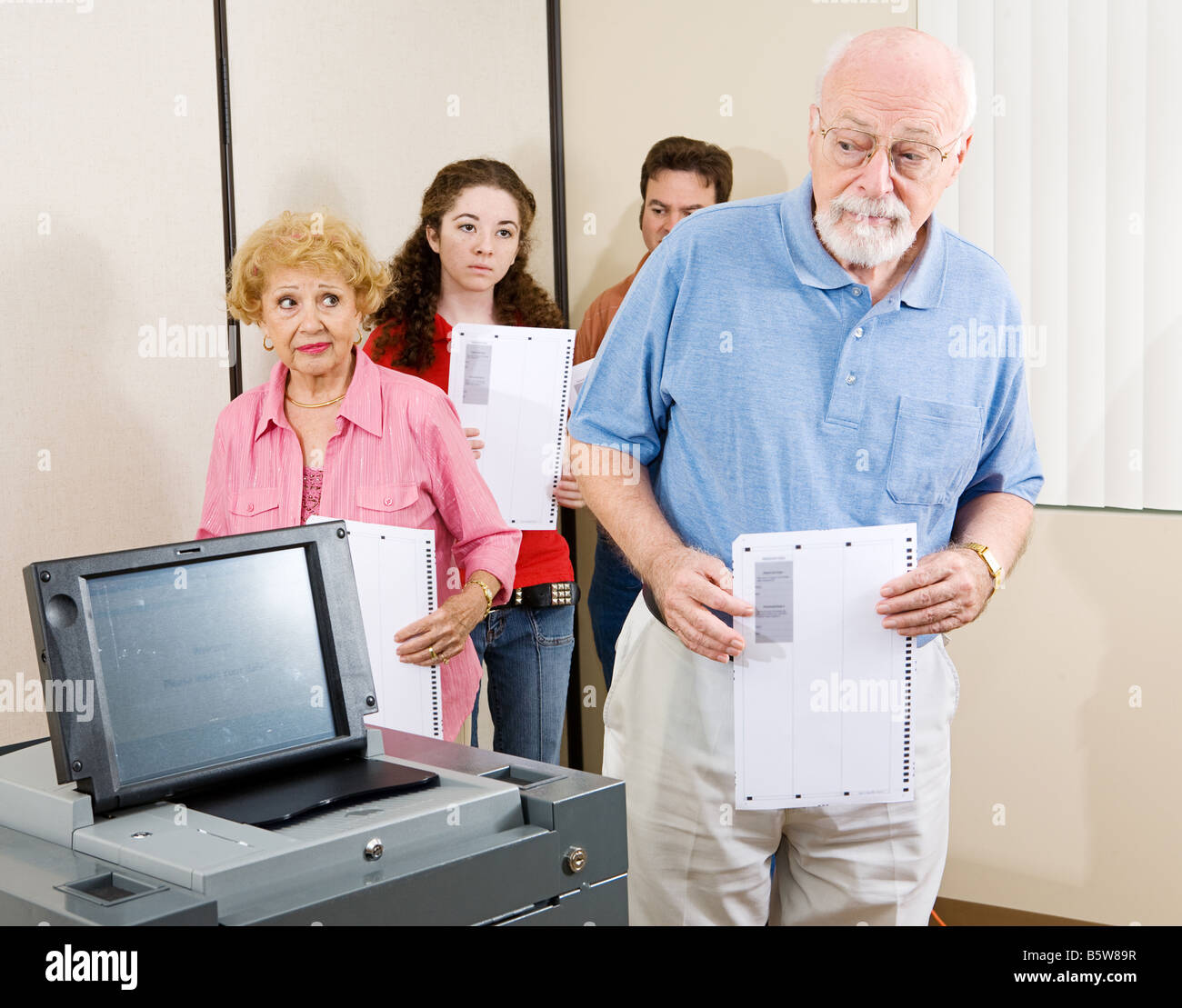 Senior uomo confuso dalla nuova scansione ottica macchina di voto Foto Stock