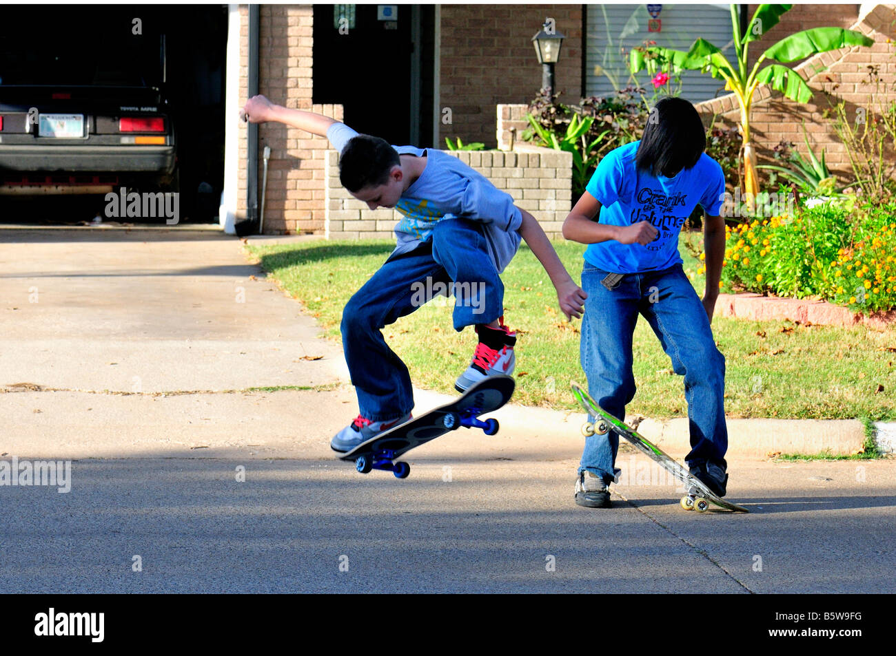 Due ragazzi adolescenti skateboard nel loro quartiere street. Oklahoma City, Oklahoma, Stati Uniti d'America. Foto Stock