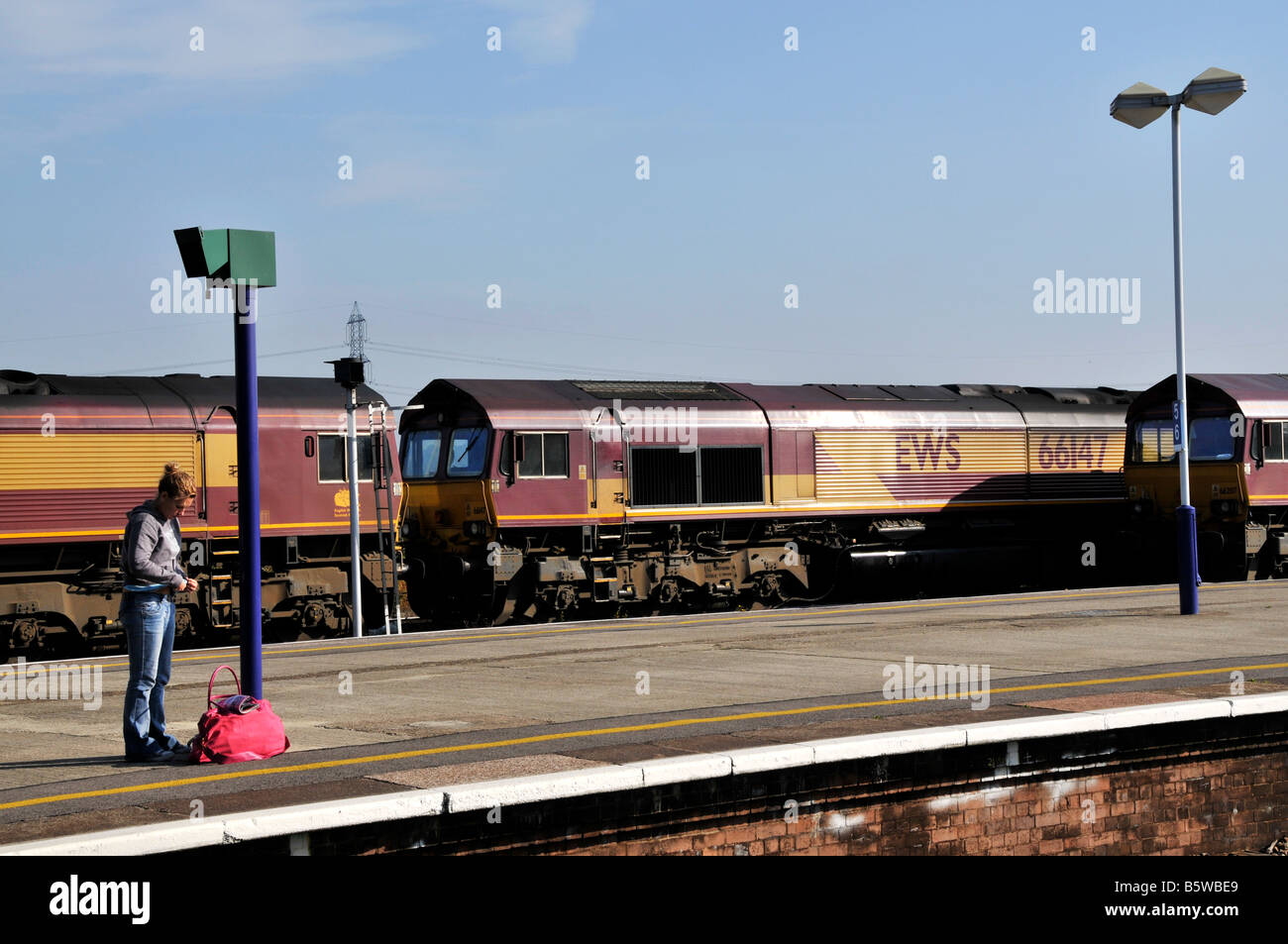 Signora giovane in attesa di un treno alla stazione di Oxford Foto Stock