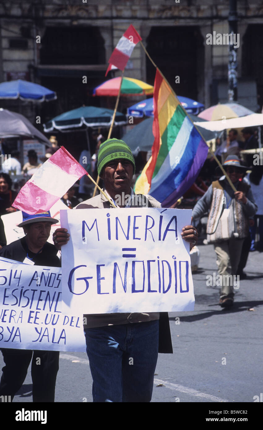 Manifestante indigeno con striscione con scritto "Mining Equals Genocide" che partecipa alla marcia di protesta, la Paz, Bolivia Foto Stock