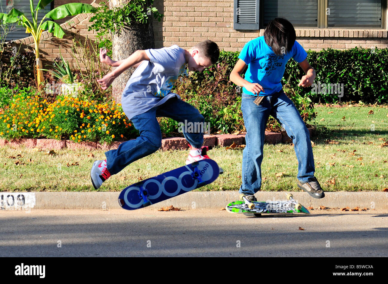 Due ragazzi adolescenti skateboard nel loro quartiere street. Oklahoma City, Oklahoma, Stati Uniti d'America Foto Stock