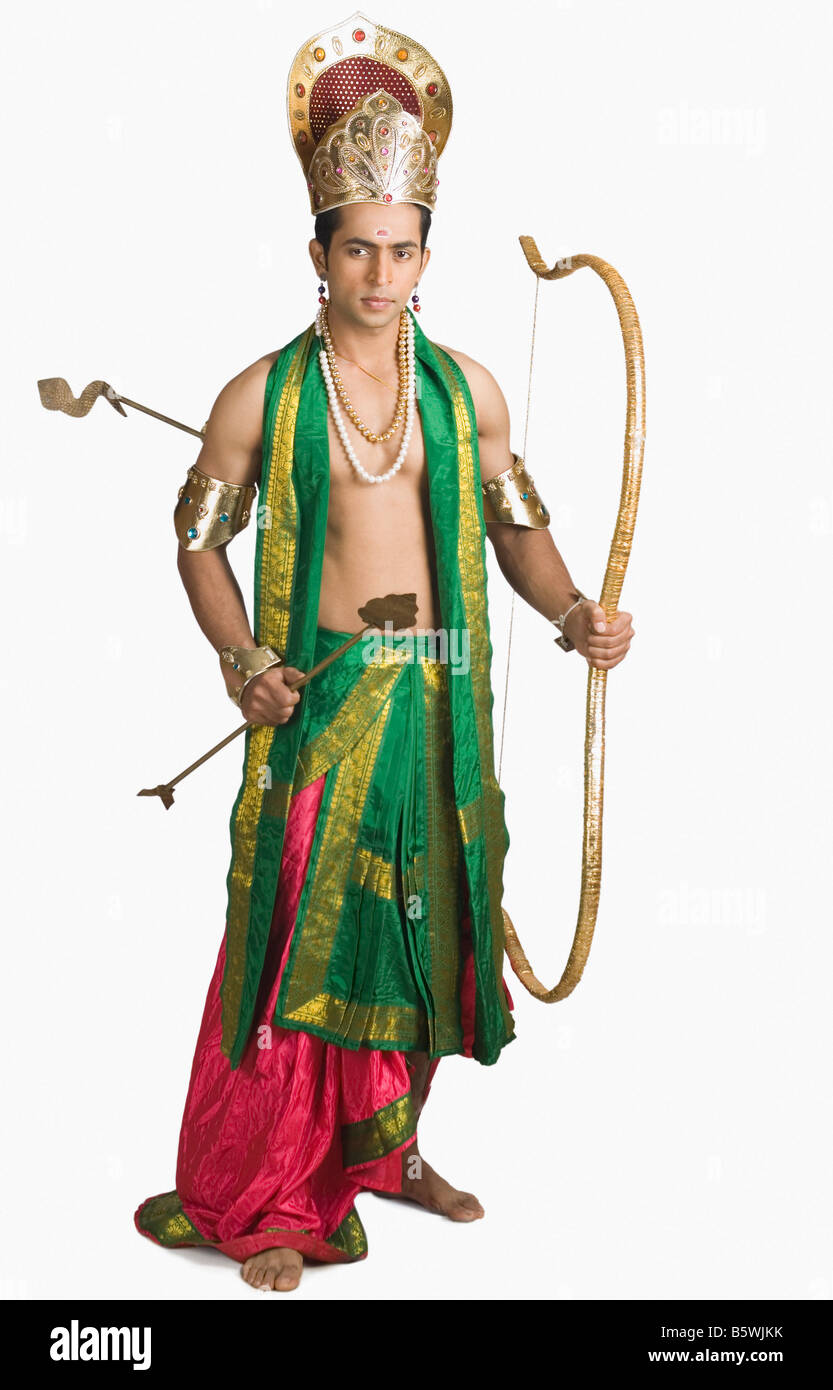 Giovane uomo in un carattere di Arjuna e tenendo un arco e frecce Foto Stock