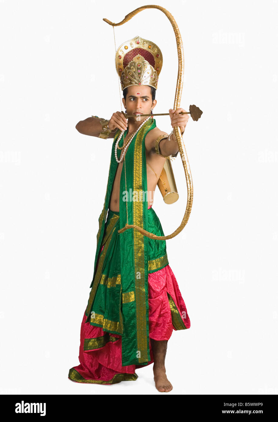 Giovane uomo in un carattere di Arjuna e tenendo un arco e frecce Foto Stock