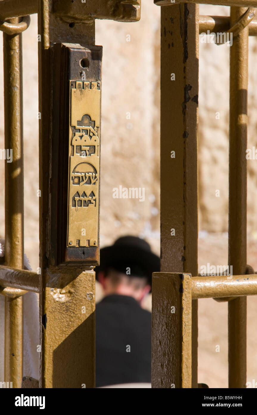 Israele Gerusalemme la città vecchia parete occidentale ebreo ortodosso pregando in corrispondenza della parete visto attraverso il recinto con mezuza Foto Stock