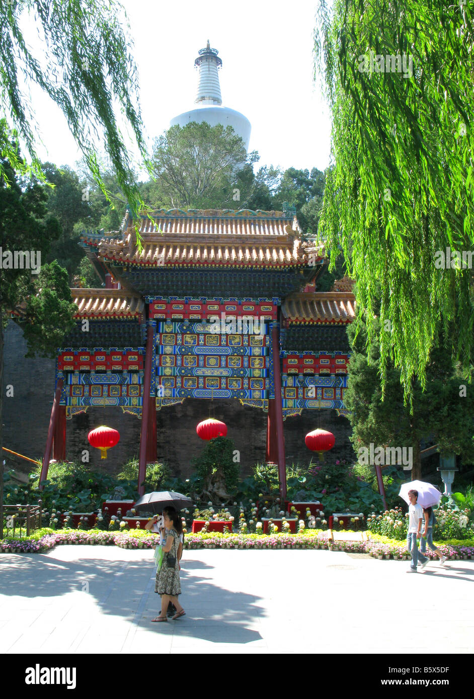 Due persone con ombrelloni all'ingresso della Pagoda Bianca sulla cima di Jade isoletta nel Parco Beihai a Pechino. Pechino Cina Asia Foto Stock