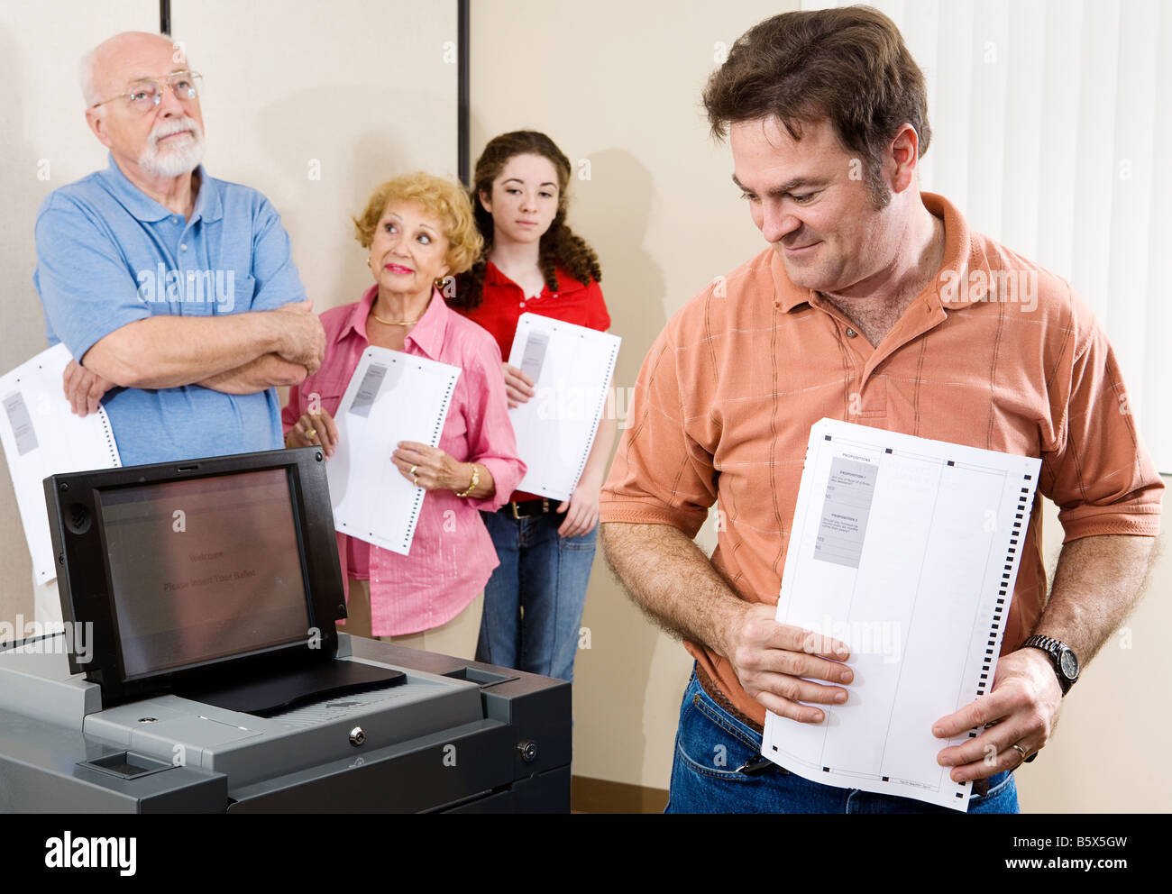 Metà uomo adulto checking out la nuova scansione ottica macchina di voto alle urne Foto Stock