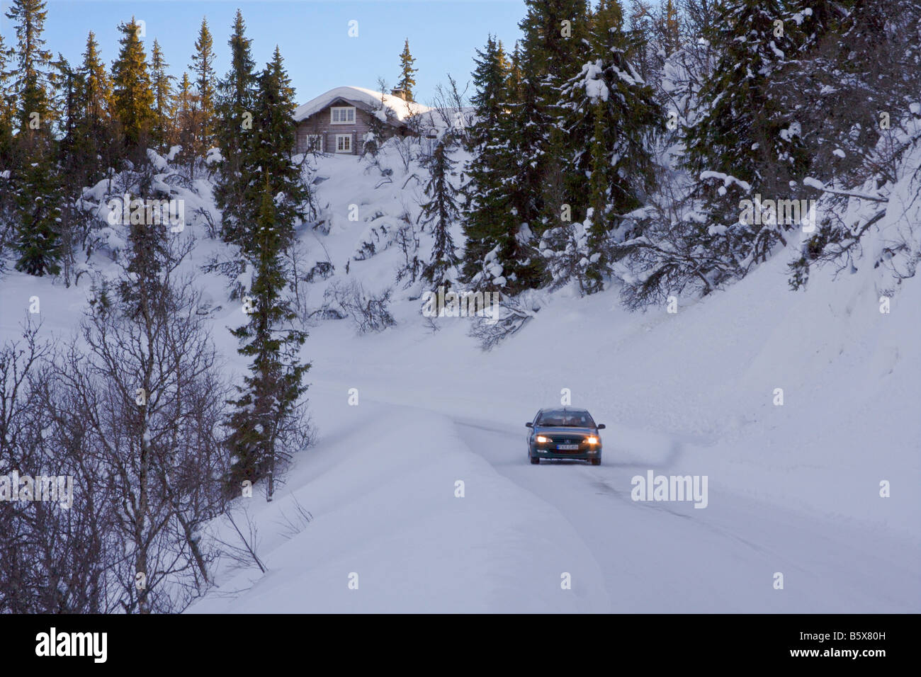 Strada innevata in inverno con la vettura si avvicina Valdres Norvegia Foto Stock