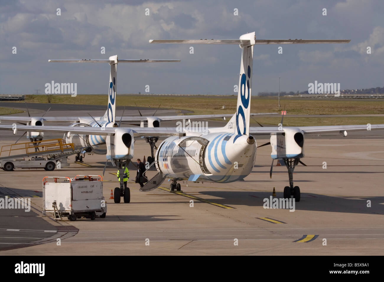 Bombardier Dash 8-Q400 aerei di linea a corto raggio appartenenti alla compagnia aerea regionale britannica Flybe a terra all'aeroporto Charles de Gaulle di Parigi. Foto Stock
