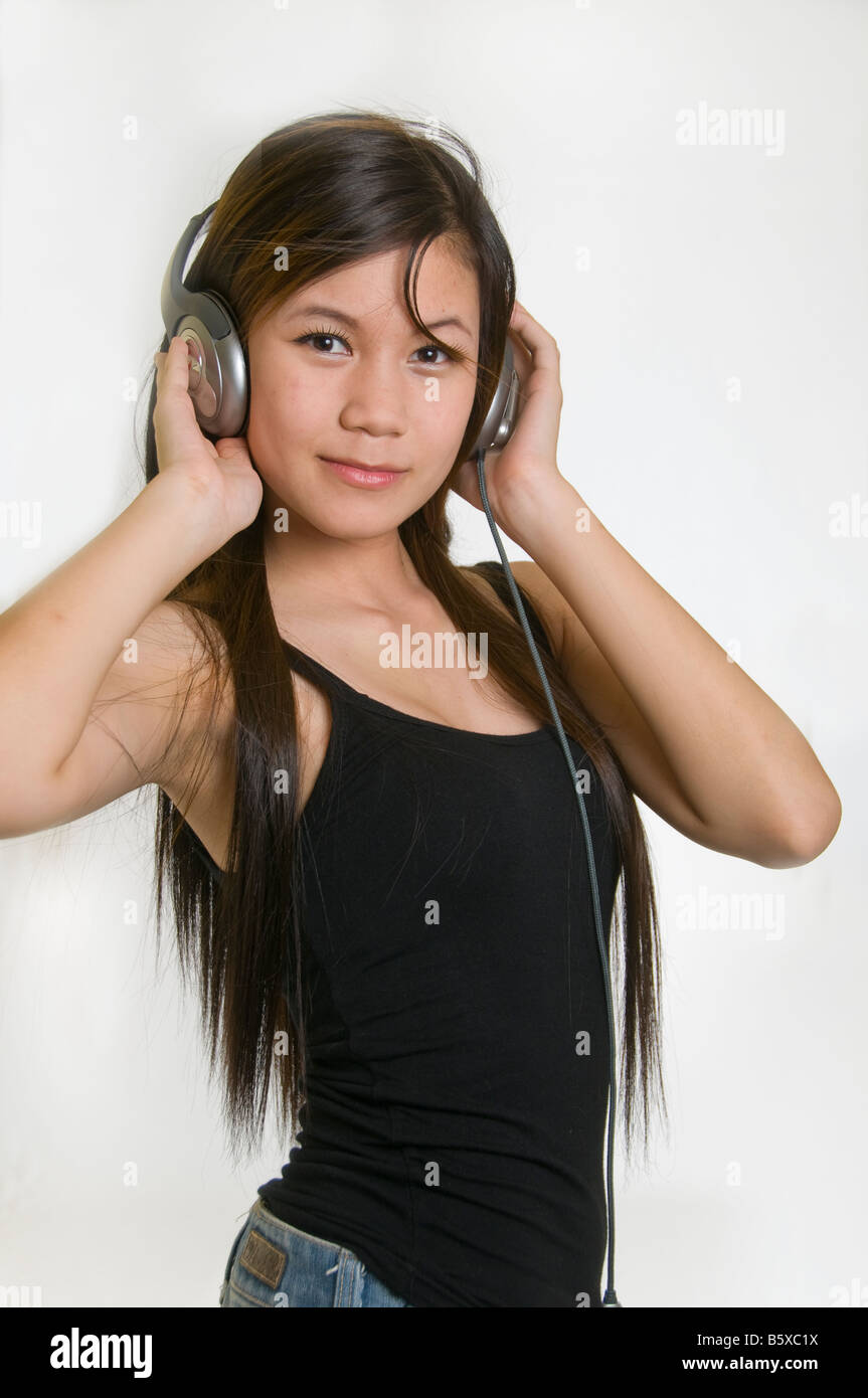 Sexy ragazza giovane ascoltando musica sulle cuffie Foto Stock