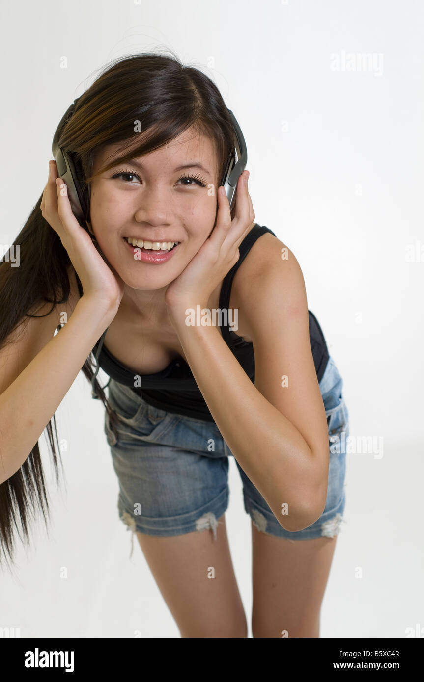 Sexy ragazza giovane ascoltando musica sulle cuffie Foto Stock