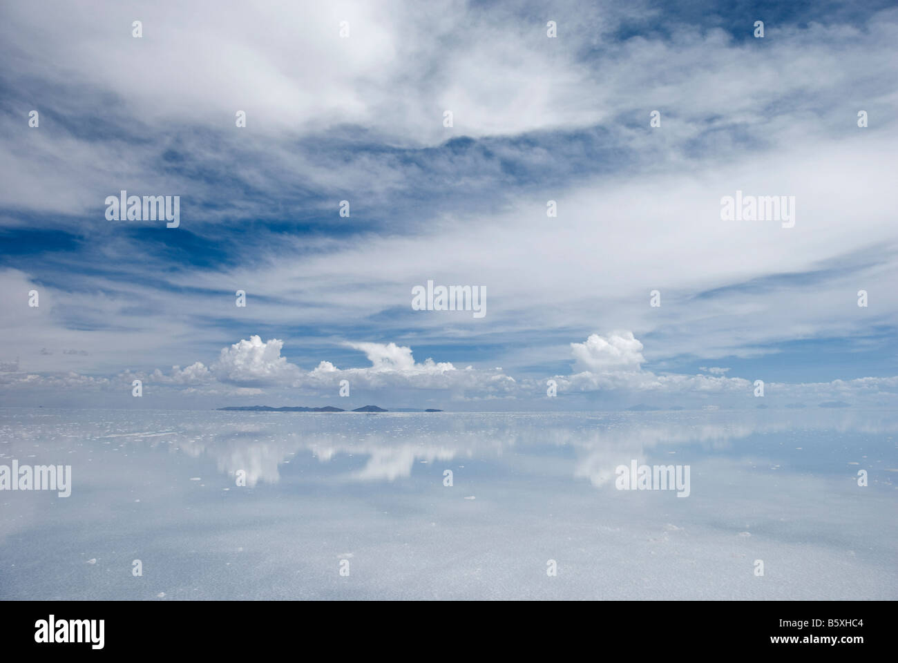 Nuvole e un'isola sono riflesse nelle acque dell'allagato Bolivina pianure di sale Foto Stock