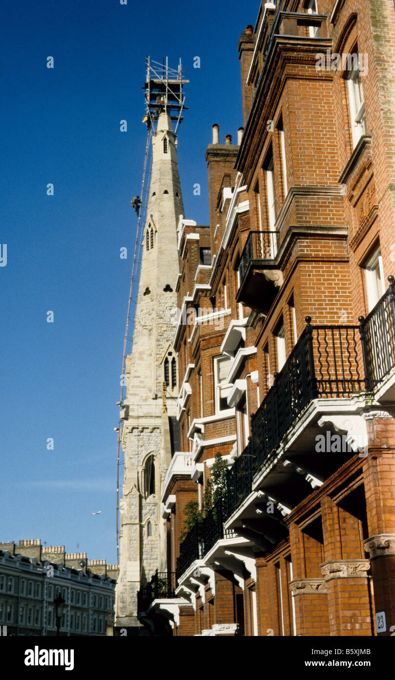 La guglia di San Pietro, la Chiesa Armena, Cranley Gardens, Kensington, Londra, con Steeplejacks e adiacente Mansion blocchi. Foto Stock