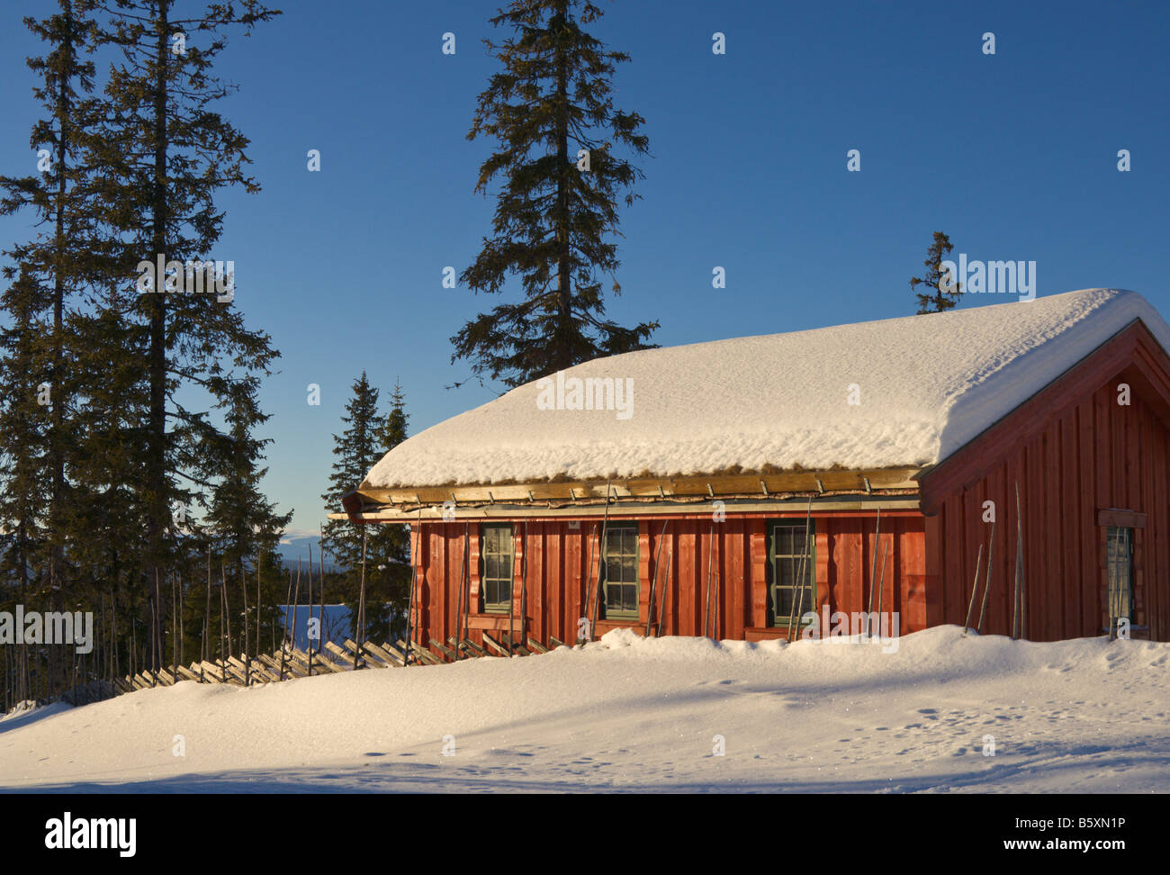 Rosso chalet per vacanze nel paesaggio innevato al crepuscolo Valdres Norvegia Foto Stock