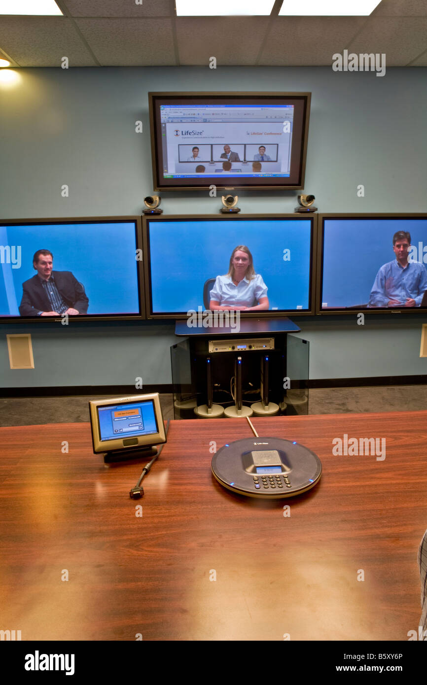 Una suite di telepresenza in Costa Mesa CA mostra gli utenti remoti in Austin TX nota dello schermo e della tastiera del telefono e vivavoce Foto Stock