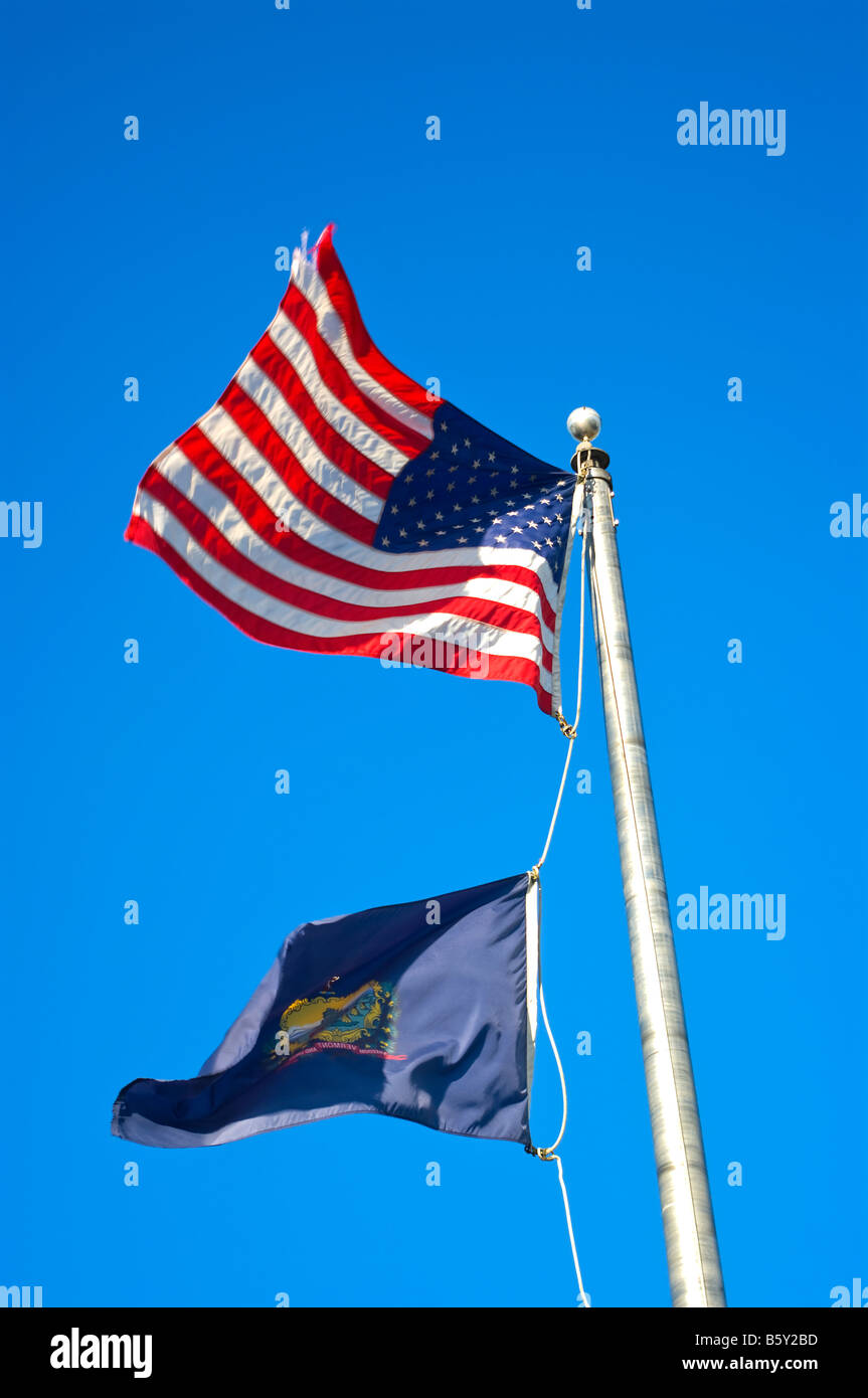 Pennone con noi bandiera sulla parte superiore e il Vermont bandiera di Stato al di sotto del vento contro un cielo blu Foto Stock