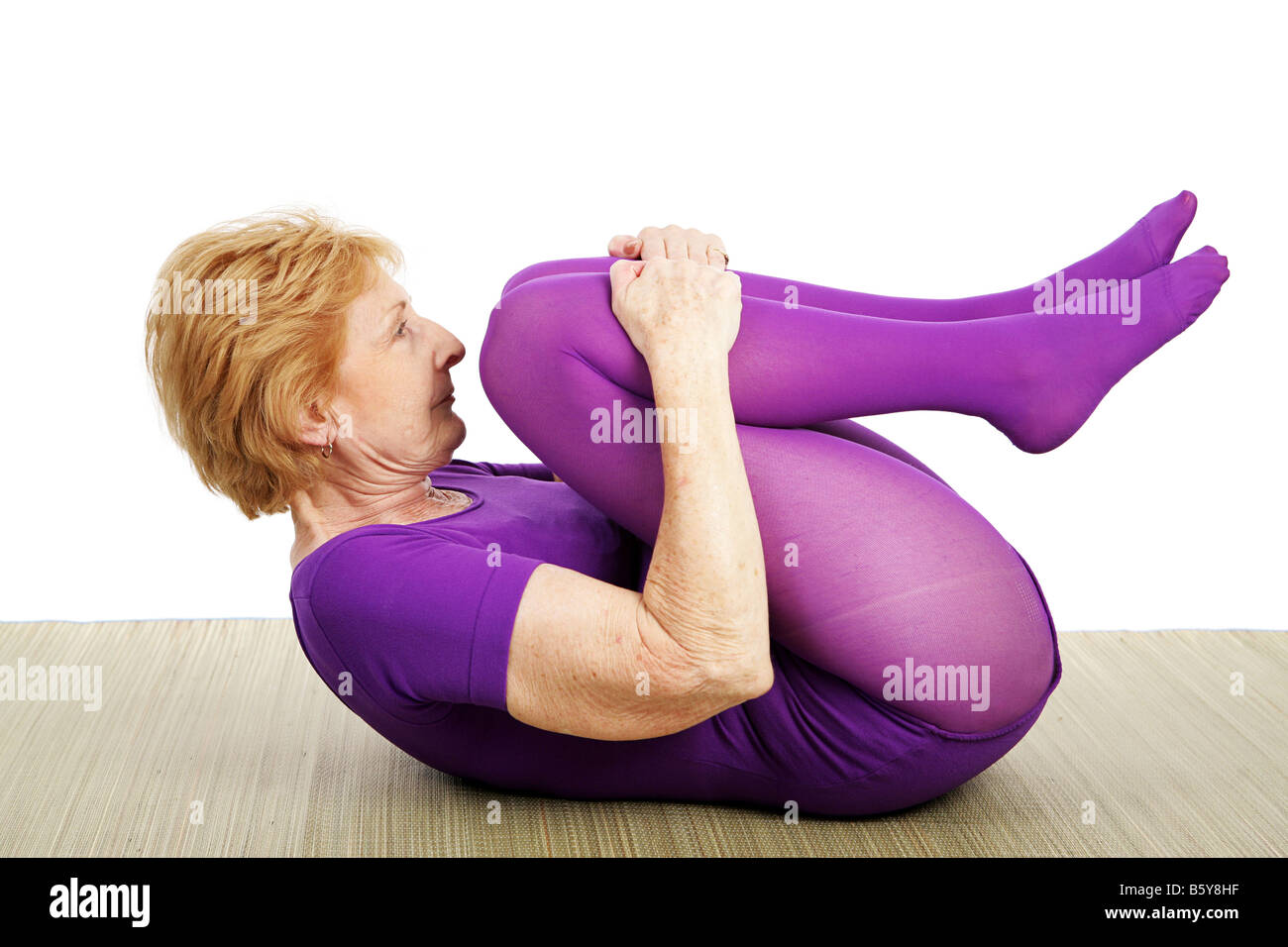 Un accoppiamento flessibile anno settanta vecchia donna facendo un suppine yoga pone sullo sfondo bianco Foto Stock Un accoppiamento flessibile anno settanta vecchia donna facendo un suppine yoga pone sullo sfondo bianco Foto Stock