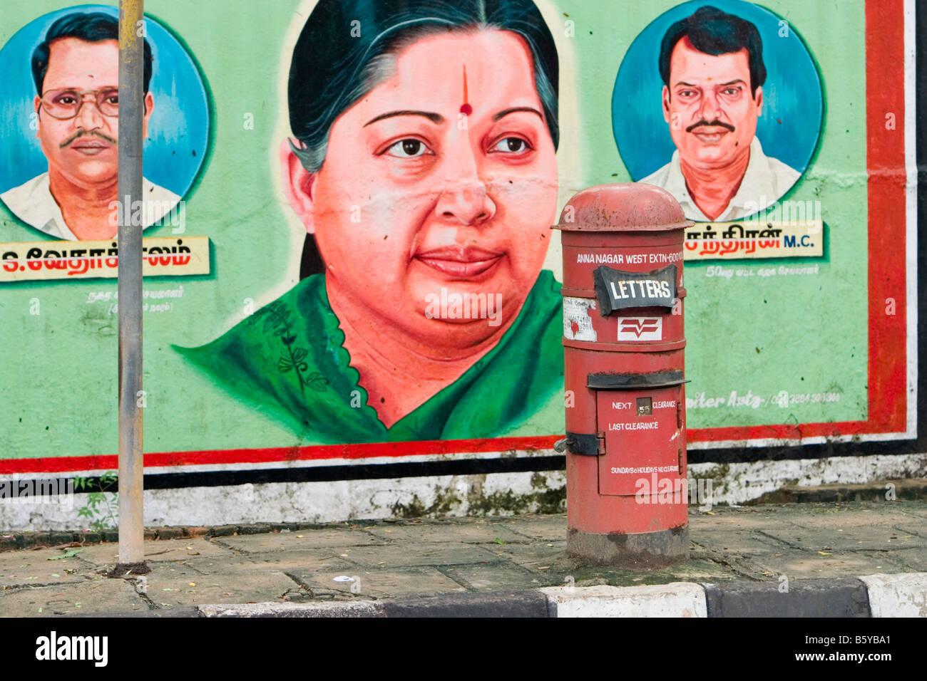 Una casella di posta del indiano servizio postale, India Post, di fronte ad una pittura murale di J. Jayalalithaa a Chennai, India Foto Stock