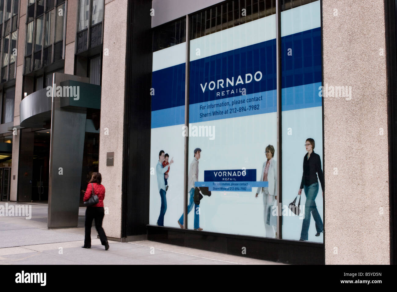 Una donna cammina davanti a un vuoto storefront pubblicizzati per leasing di Vornado Realty Trust a Manhattan, New York Foto Stock