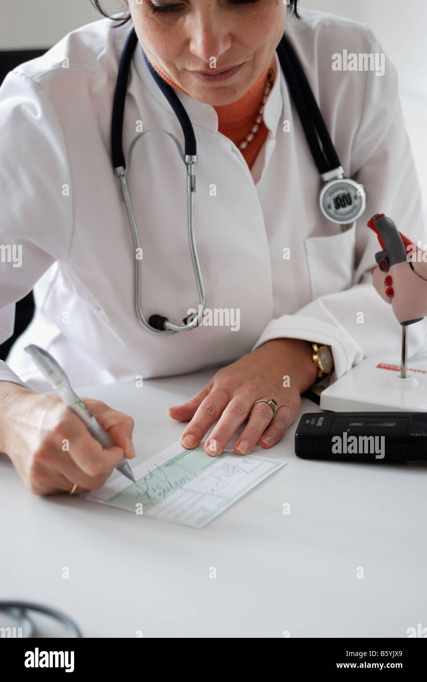 Medico donna scrive un malato nota Foto Stock