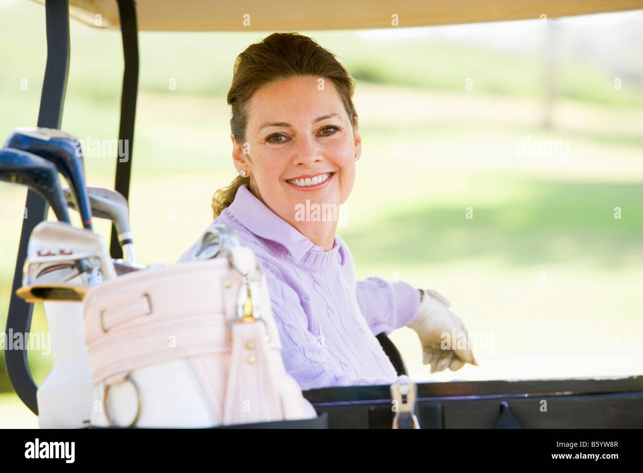 Ritratto di donna seduta in un carrello da golf Foto Stock