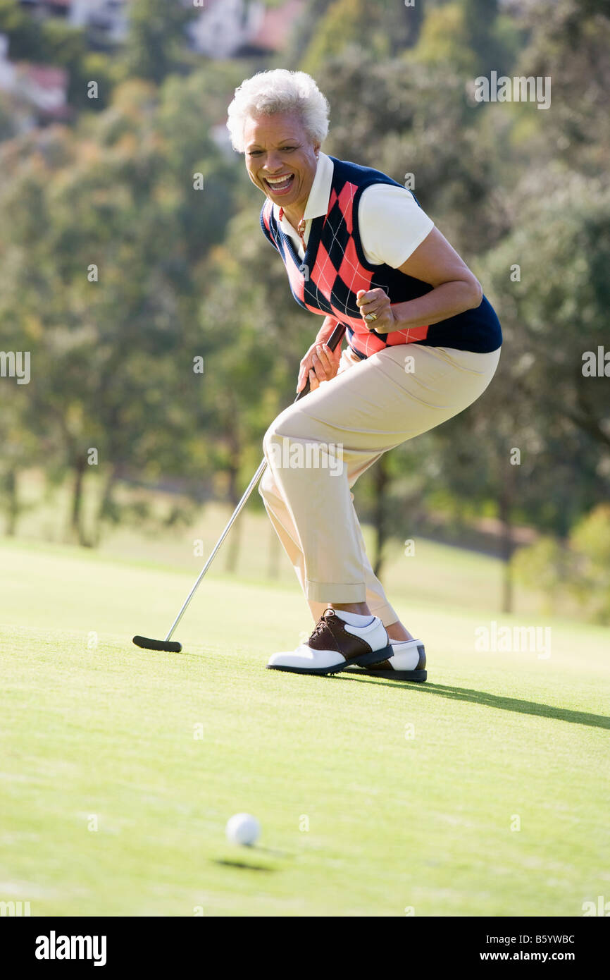 Donna giocando una partita di golf Foto Stock