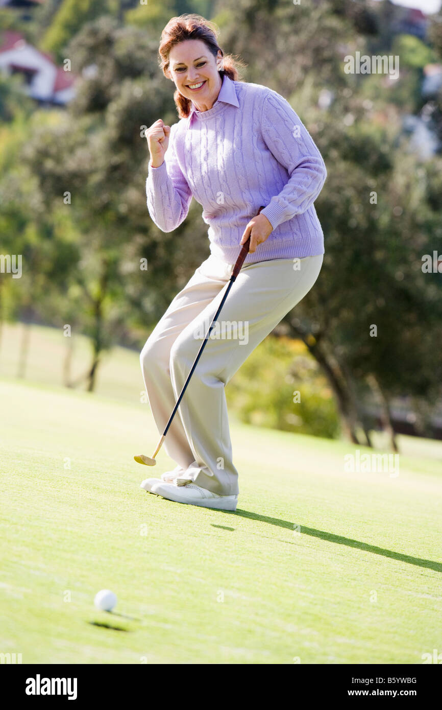 Donna giocando una partita di golf Foto Stock