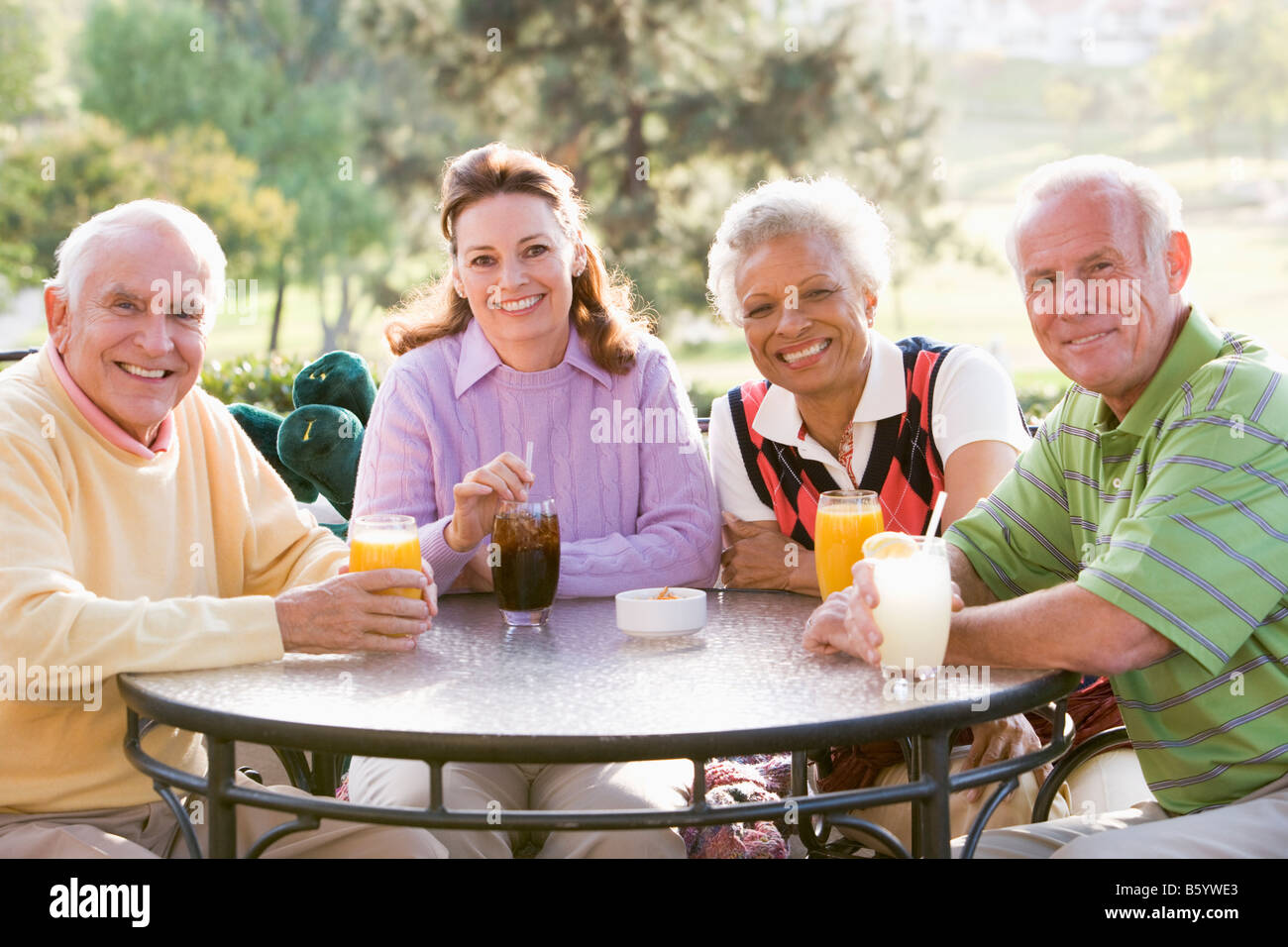 Gli amici sorseggiando una bevanda da un campo da Golf Foto Stock