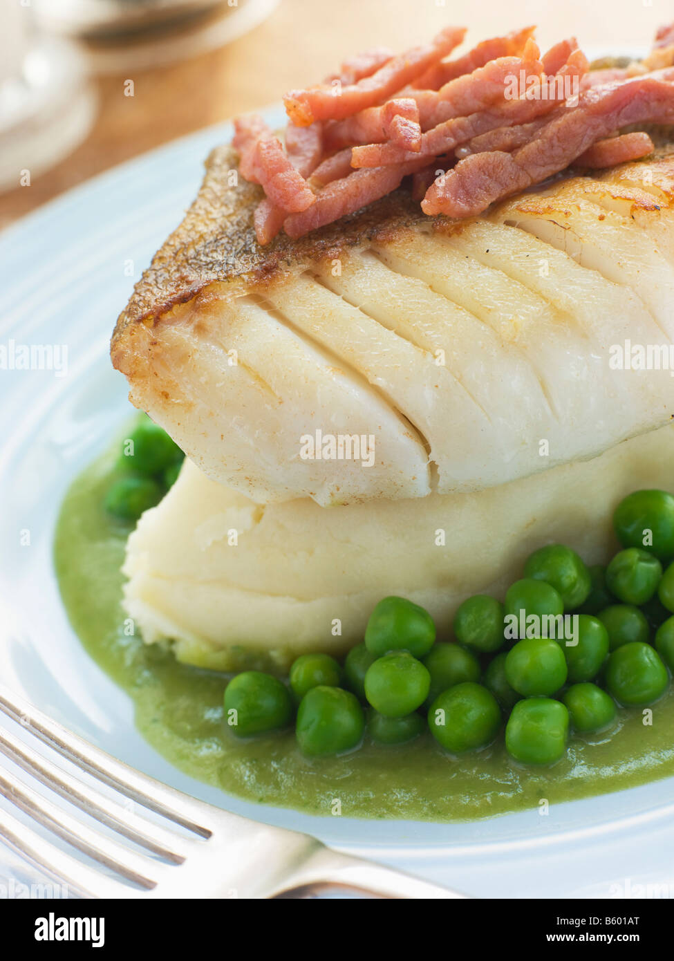 Merluzzo arrosto di filetto con purè di piselli di patate e pancetta Foto Stock