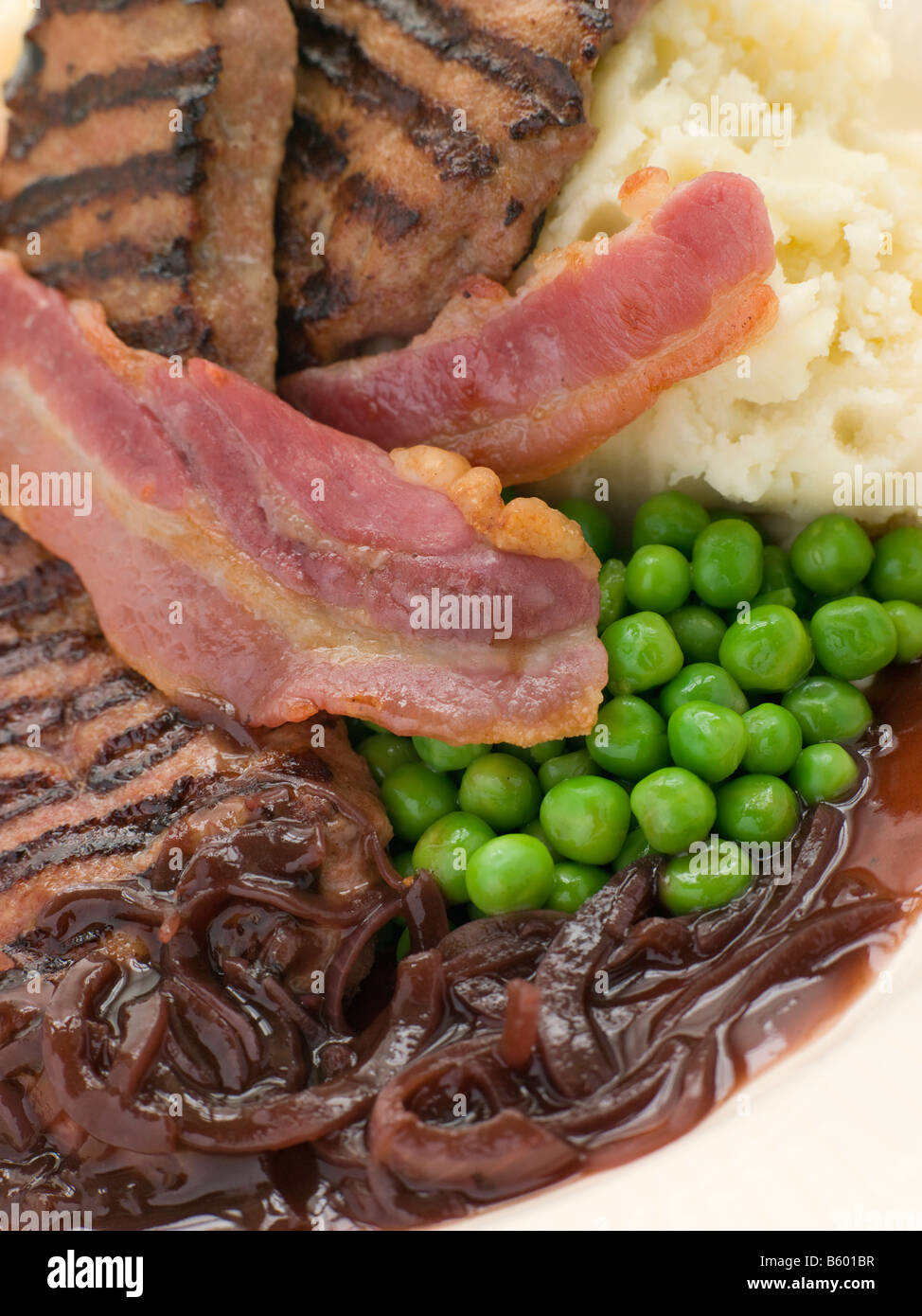 Grigliata di vitelli di fegato e pancetta con purea di patate e piselli Foto Stock