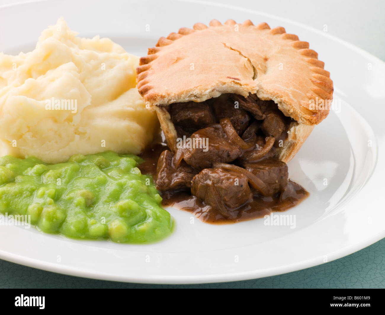 Steak Pie e schiacciare con fiacco piselli Foto Stock