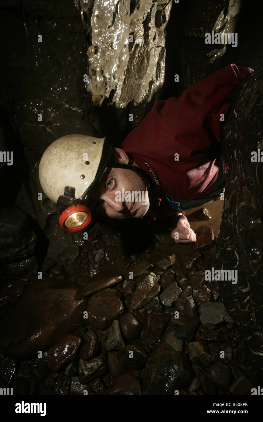 Un speleologo negozia un squeeze in Ponte Grotta del Neath Valle del Galles del Sud del Parco Nazionale di Brecon Beacons Foto Stock