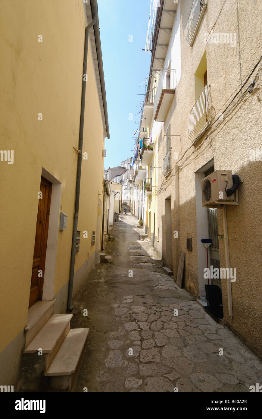 Una stretta viuzza in collina comune di Calitri con la vecchia signora a piedi a casa con il suo shopping Foto Stock